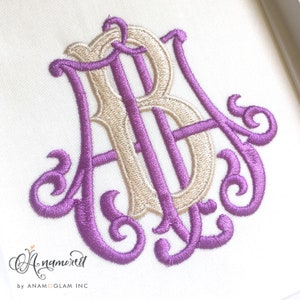 May include: A monogram embroidery design featuring the letters "AB" in a decorative script font. The "A" is in purple and the "B" is in beige. The letters are intertwined and have a vintage style.
