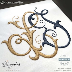 May include: An embroidery design on white fabric featuring an intertwined monogram with gold and dark navy blue thread. The text Hand-drawn and Tested appears at the top, with a 100% HUMAN MADE NO AI USED circular seal and Anamored.com text.
