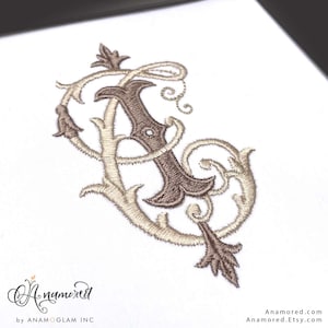 Peut inclure: Monogram brodé en fil marron et beige sur fond blanc. Les lettres entrelacées présentent des volutes et des ornements décoratifs. Le design comprend le texte "Anamored" et "Anamored.Etsy.com".