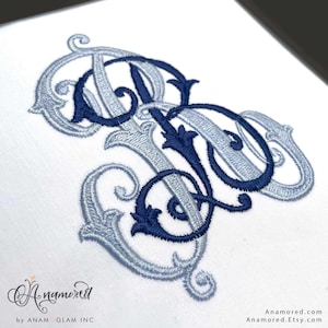 Może przedstawiać: Haftowany monogram w kolorze granatowym i jasnoniebieskim na białym tle. Projekt przedstawia splecione litery z ozdobnymi zdobieniami i detalami. Widoczna nazwa sklepu Etsy i strona internetowa.