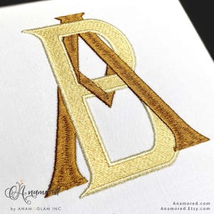 May include: Embroidered monogram featuring the letters "A" and "R" in a decorative, intertwined design. The letters are in shades of gold and brown, stitched on a white background. The design has a classic, elegant aesthetic.