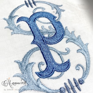 Puede incluir: Una letra bordada "P" azul con un diseño floral decorativo en tonos azules sobre un fondo blanco.