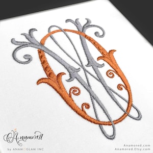 May include: Embroidered monogram in gray and orange on a white background. The monogram features the letters "AN" intertwined within an oval frame, with decorative flourishes. The design is detailed and elegant, suitable for personalization.