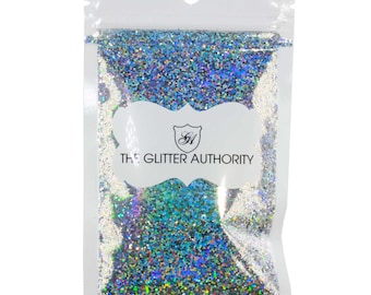 May include: A resealable plastic bag filled with iridescent holographic glitter. The bag has a white label with the text "The Glitter Authority" and a logo.