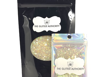 May include: Two resealable bags of iridescent glitter with a white star design. The larger bag is black with the text "The Glitter Authority" in white. The smaller bag is iridescent with the same text in white.