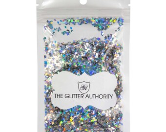 May include: A resealable plastic bag filled with iridescent holographic diamond-shaped glitter. The bag has a white label with the text "THE GLITTER AUTHORITY" and a logo.