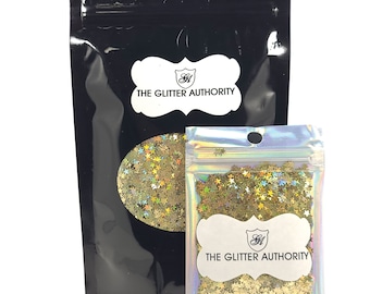 May include: Two resealable bags of gold glitter with a star shape. The larger bag has a white label with the text "THE GLITTER AUTHORITY". The smaller bag has a similar label.