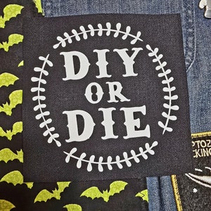 May include: A black fabric patch with white stitching around the edges. The patch has a white circle with the text "DIY OR DIE" in white letters.