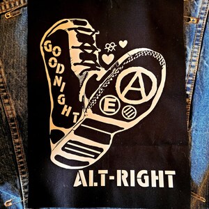 May include: Black and white patch with a boot design and the text "GOODNIGHT ALT-RIGHT". The boot has an anarchy symbol and the letter "E" on it.