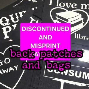 May include: Black fabric patches and bags with white text. The image includes patches with phrases like "I love my library" and "Go Away". A pink rectangle states "DISCONTINUED AND MISPRINT back patches and bags."