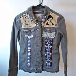 May include: A green denim jacket with a variety of embellishments, including buttons, studs, and fabric patches. The patches feature images of women and a leopard print design.