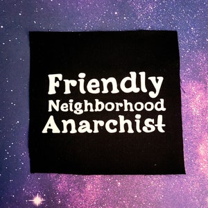 K&ouml;nnte beinhalten: Schwarzer Stoff-Patch mit wei&szlig;em Text, der "Friendly Neighborhood Anarchist" lautet.
