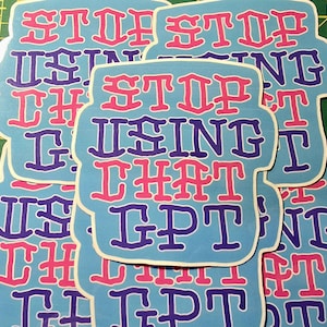 May include: A collection of light blue stickers with the text "STOP USING THAT GPT" in pink and purple. The stickers have a white border and are arranged on a green cutting mat.