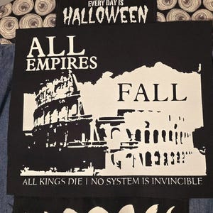 Könnte beinhalten: Schwarz-weißes Patch mit dem Text "EVERY DAY IS HALLOWEEN" oben. Unter dem Text befindet sich ein Schwarz-Weiß-Bild eines Gebäudes mit dem Text "ALL EMPIRES FALL" und dem Text "ALL KINGS DIE | NO SYSTEM IS INVINCIBLE" unten.