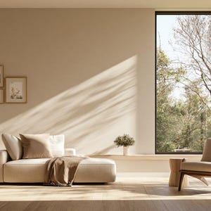 Könnte beinhalten: Eine beige Récamiere mit einer braunen Decke und Kissen, ein Holz-Sessel, eine Topfpflanze und vier gerahmte Wandbilder. Der Raum verfügt über helle Wände, einen Holzboden und ein großes Fenster mit Blick auf Bäume.