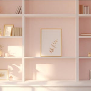 Peut inclure: Une bibliothèque blanche à six étagères, chacune remplie de divers objets décoratifs, notamment des œuvres d'art encadrées, des livres et de petites sculptures. La bibliothèque est placée contre un mur rose pâle.