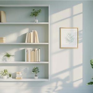 May include: A white bookshelf with five shelves, filled with books, plants, and framed artwork. The bookshelf is against a light blue wall.