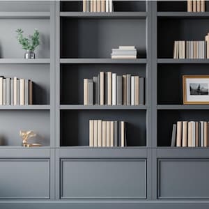 Puede incluir: Una gran estantería empotrada de color gris oscuro con múltiples estantes llenos de filas de libros en tonos neutros. La unidad incluye plantas decorativas en macetas, un pequeño marco de fotos y un objeto metálico sobre una pared con paneles.