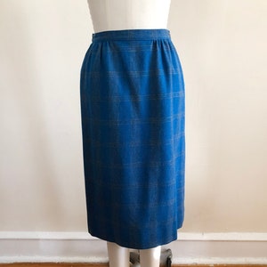 May include: A blue and brown plaid skirt with a high waist and a straight silhouette.