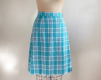 May include: A blue and white plaid skirt with a straight silhouette. The skirt is knee-length and has a simple design.