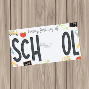 May include: A rectangular sign featuring the text "happy first day of SCHOOL" in black lettering. The white background is decorated with colorful illustrations of a yellow school bus, a red apple, a small chalkboard, and pencils.