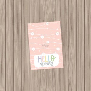 Puede incluir: Tarjeta imprimible rosa con un patrón floral blanco y el texto "Hello spring" en colores arcoíris.