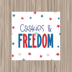 May include: White printable tag with red and blue stars and the text "Cookies & Freedom".