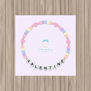May include: A pastel-colored beaded bracelet with the word "VALENTINE" spelled out in white letters. The beads are in shades of pink, yellow, blue, and purple.
