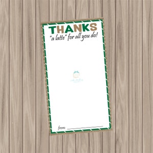 May include: A white card with a green and brown border and the words "THANKS" and "a latte for all you do!" in green and brown text. The card has a blank space for a message and a line for "from:" on a wooden background.
