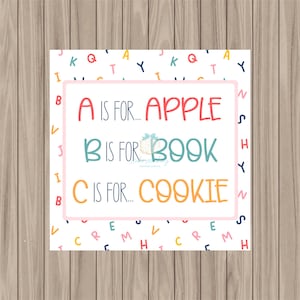 Può includere: Una scheda quadrata con sfondo bianco e lettere colorate. Il testo recita "A is for... APPLE", "B is for... BOOK" e "C is for... COOKIE" in rosso, verde acqua e arancione, rispettivamente, all'interno di un bordo rosa.