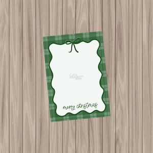 May include: A Christmas-themed greeting card with a green plaid border and a scalloped edge. The card has a white interior with the words "merry christmas" in a script font. A green bow is at the top.