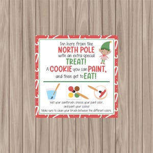 May include: A square sign with a red border and candy cane accents. The sign reads "I'm here from the North Pole with an extra special TREAT! A COOKIE you can PAINT, and then get to EAT!" with instructions and illustrations.