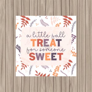 May include: A white printable sign with a fall-themed design. The sign features a pink background with the text "a little fall treat for someone sweet" in orange, red, and purple letters. The background is decorated with small orange, purple, and black leaves.
