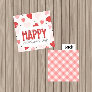 May include: A white card with a red heart pattern and the text "HAPPY valentine's day". The back of the card has a pink and white gingham pattern.