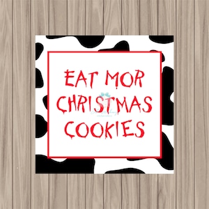 May include: A white and black cow print background with a red border and the text "EAT MOR CHRISTMAS COOKIES" in red.