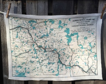 May include: A rectangular map of Algonquin Provincial Park in Ontario, Canada, printed on a light-colored fabric. The map features teal blue lakes and a network of roads and railways. Text includes "Canadian National Railways" and "Save the Forest and Camp Again."