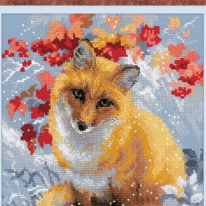 Puede incluir: Primer plano de un zorro rojo sentado en la nieve con bayas rojas en el fondo.