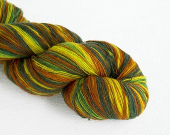 May include: A skein of yarn with green, yellow, and orange stripes. The yarn is twisted into a loose coil.