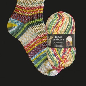 May include: A knitted sock with a vibrant pattern of red, yellow, green, and blue stripes, alongside a ball of Opal yarn. The yarn ball is labelled with "100 g ca. 425 m". The sock is a cozy, handmade item.