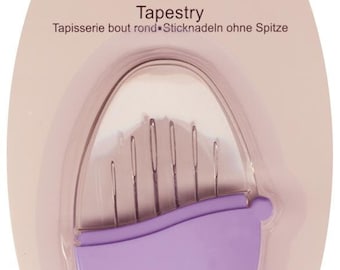以下が含まれることがあります： John James Pebble Tapestryの針のパッケージ。 楕円形のパッケージで、背景は薄いピンク色、透明な窓があります。 6本の銀色の針がラベンダー色のホルダーに収められています。 パッケージには「6 Needles Size 18/24」と書かれています。