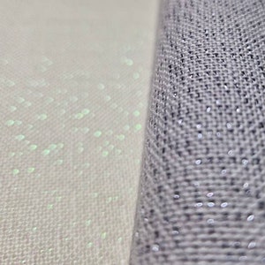 May include: Close-up of two fabrics, one white with a subtle shimmer and the other a dark gray with a textured weave.