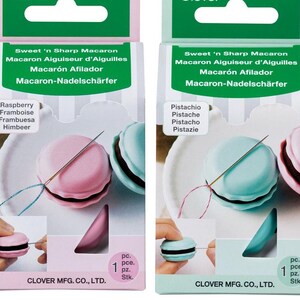 Puede incluir: Dos paquetes de enhebradores de aguja Clover Sweet 'n Sharp Macaron. El paquete de la izquierda es rosa y dice "Raspberry, Framboise, Frambuesa, Himbeer". El paquete de la derecha es azul y dice "Pistachio, Pistache, Pistacho, Pistazie". Ambos paquetes tienen una imagen de un macaron con una aguja enhebrada.