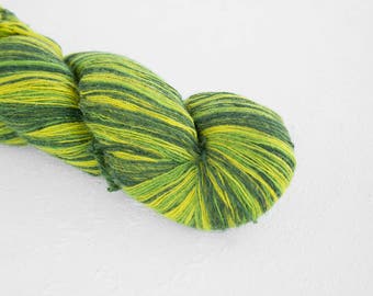 May include: A skein of yarn with green and yellow stripes. The yarn is soft and fluffy, and it would be perfect for knitting or crocheting.