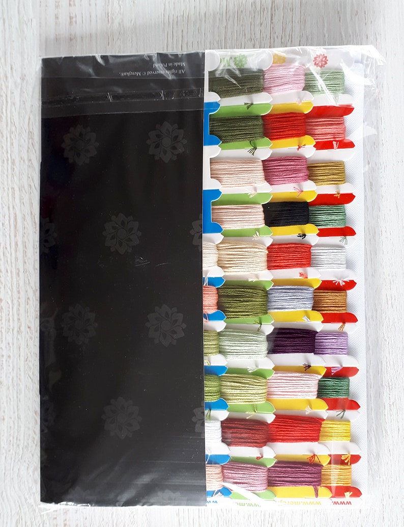 May include: A set of embroidery floss in a variety of colors, including red, green, yellow, pink, and purple. The floss is organized in a plastic container with a black background. The text "All rights reserved c. Marigolds" and "Made in Taiwan" is printed on the container.