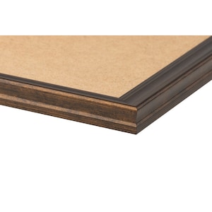 May include: Close-up of a dark brown wooden picture frame with a light brown interior. The frame has a detailed, textured design and a beveled edge. The corner of the frame is visible against a white background.
