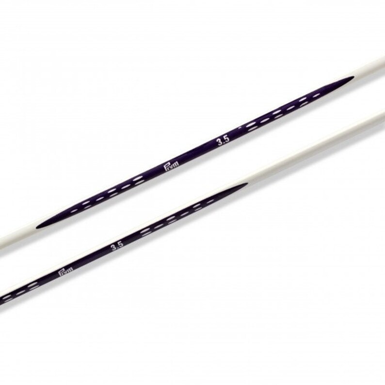 May include: Two white knitting needles with purple markings. The needles are 3.5 mm in size.
