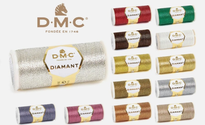 K&ouml;nnte beinhalten: Eine Sammlung von DMC Diamant Stickgarn-Spulen in verschiedenen Metallic-Farben, darunter Silber, Gold, Rot, Gr&uuml;n, Braun und mehr. Jede Spule tr&auml;gt das DMC-Logo und das Wort "Diamant".