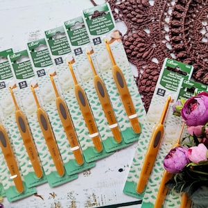 May include: A set of ten gold crochet hooks in various sizes, ranging from 2.5 mm to 7.5 mm. The hooks are packaged individually and labeled with their size and the brand name "Clover".