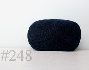 May include: A ball of dark blue yarn with the number #248 printed on a white surface.