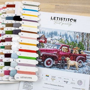 May include: A cross stitch pattern featuring a red pickup truck with a Christmas tree in the back and a group of dogs. The pattern is titled "L8014 Christmas Delivery" and is by Zweigart Anchor.